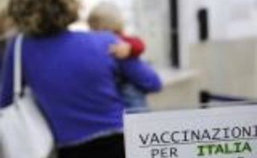 Una madre con il figlio in braccio chiede informazioni sulla somministrazione del vaccino contro l'H1n1