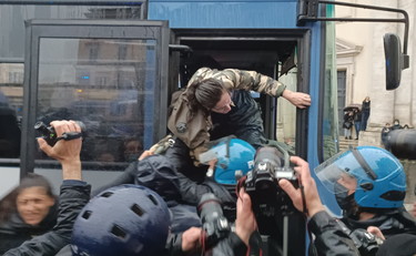 Spintoni e insulti con la polizia, manifestante caricata di peso sulla camionetta