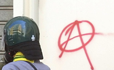 Cassonetti in fiamme e banche danneggiate, blitz degli anarchici a Roma