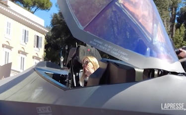 Meloni si trasforma in una Top Gun e sale sull'F-35: bambini in festa | GUARDA