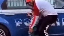 Fa orinare il figlio sull'auto della polizia, il video che indigna: Remigrazione