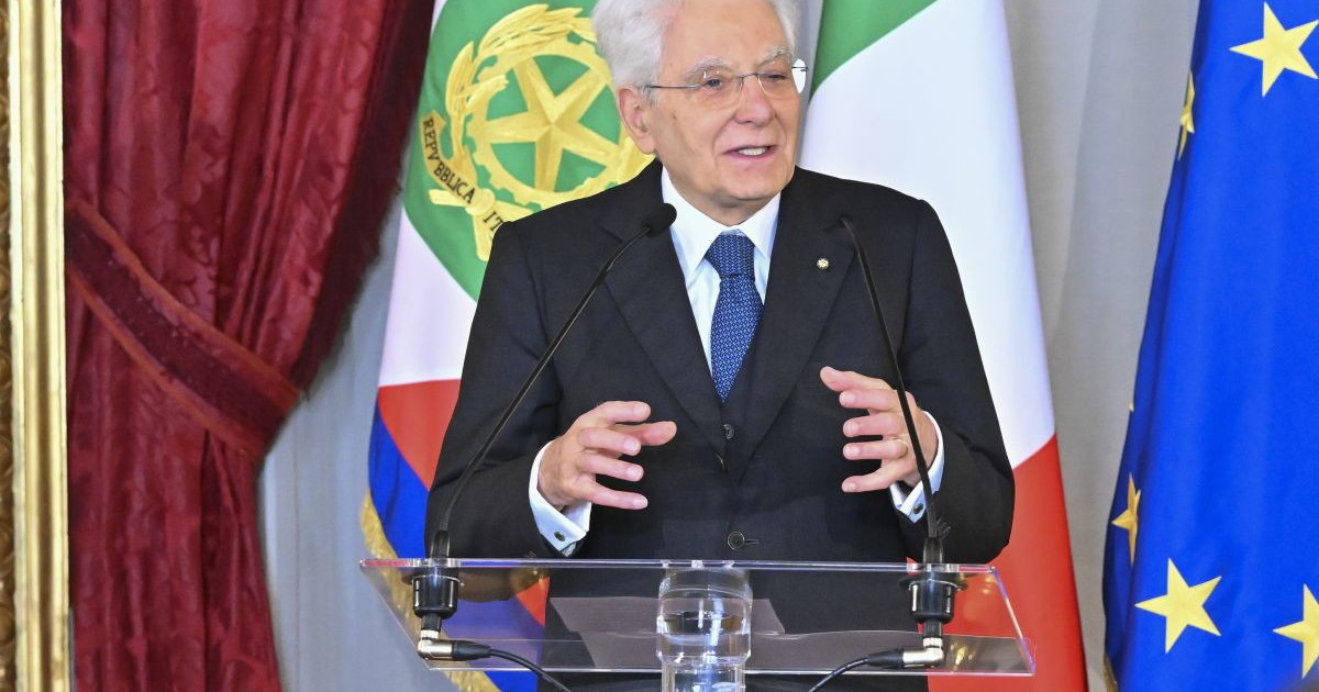 Presidente della in uniforme davanti alla bandiera della Marina Militare e dello stendardo della Guardia costiera